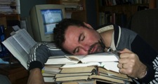 slumped over pile of books