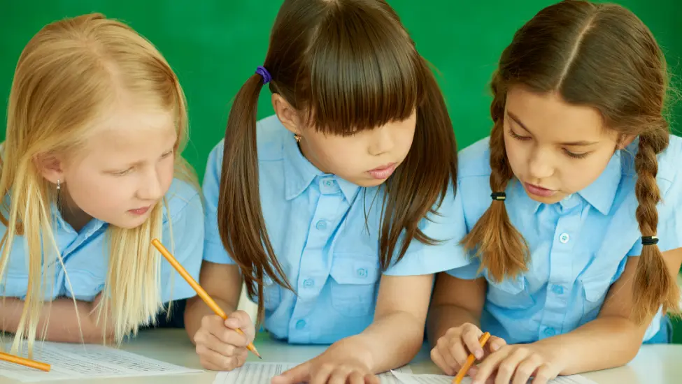 three young girls working together to solve a problem