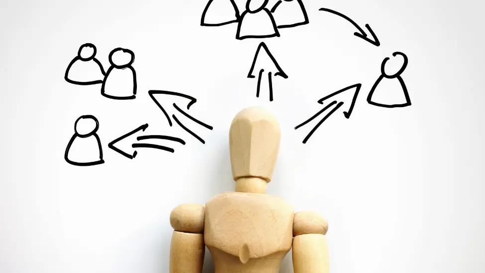 wood model of person with arrows pointing to groups of other people