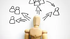 wood model of person with arrows pointing to groups of other people