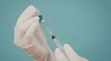 Gloved hands preparing injection