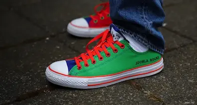 custom converse sneakers in the joomla colour scheme with the text joomla rocks embroidered on the heel
