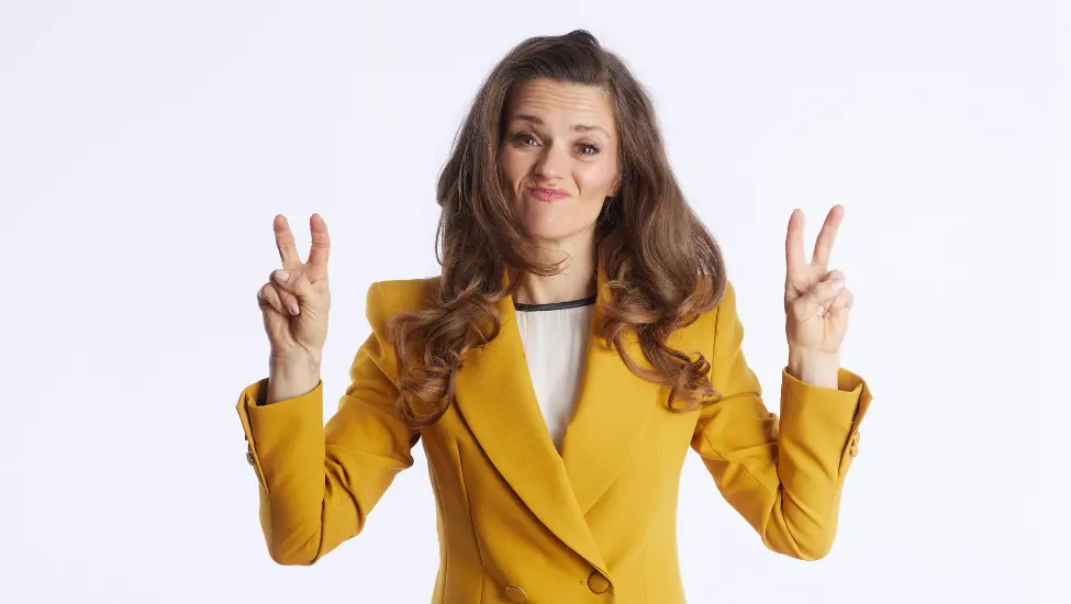 women in yellow jacket holding fingers as air quotes