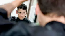 good looking man admiring himself in the mirror